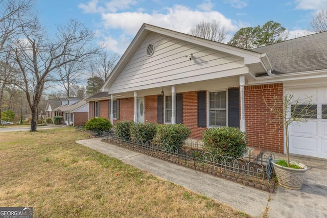 view of side of property with a shingled roof, brick siding, a lawn, and an attached garage