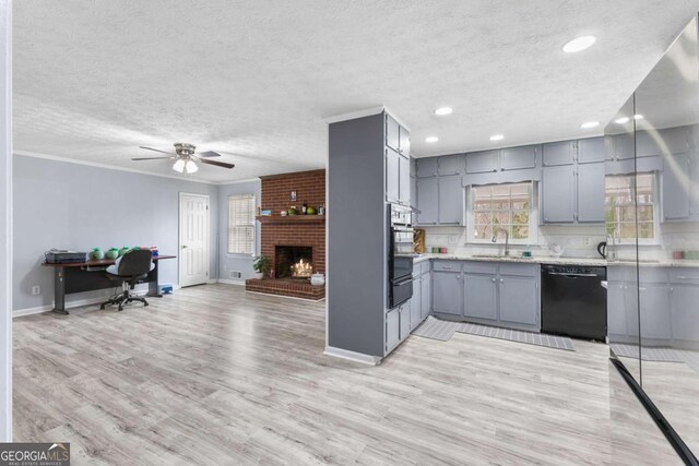 kitchen with black dishwasher, gray cabinetry, open floor plan, a sink, and light wood-type flooring