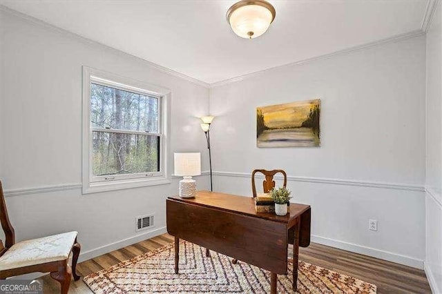 home office featuring visible vents, crown molding, baseboards, and wood finished floors