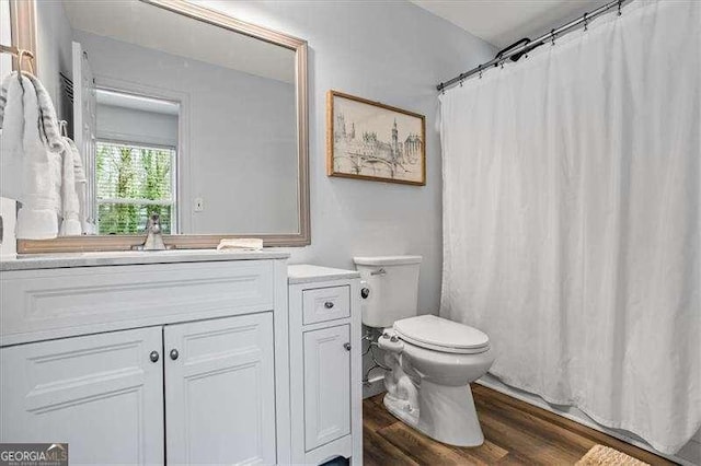 bathroom with curtained shower, vanity, toilet, and wood finished floors