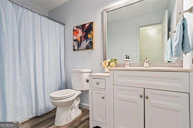 bathroom featuring a shower with shower curtain, vanity, toilet, and wood finished floors