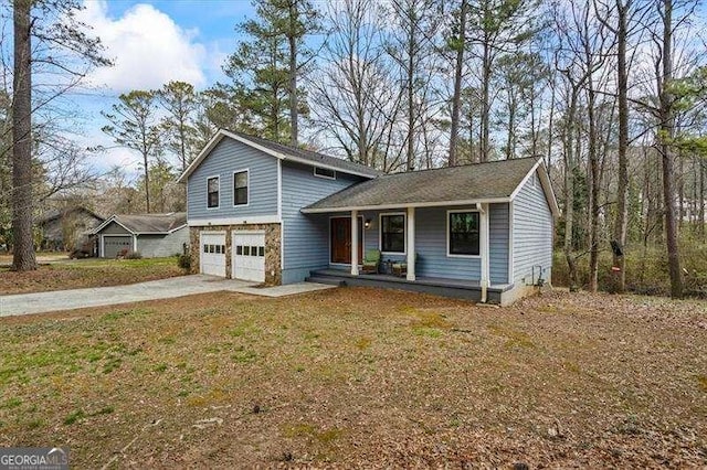 split level home featuring driveway, a garage, a front lawn, and a porch