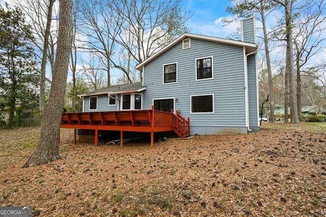 back of house with a deck and a chimney