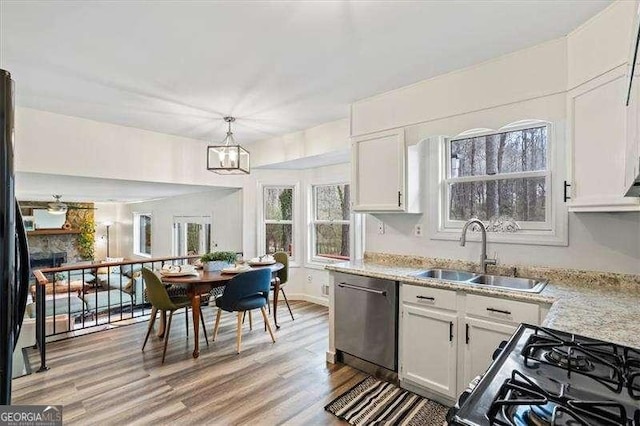 kitchen featuring a sink, white cabinets, light wood-style floors, light countertops, and dishwasher