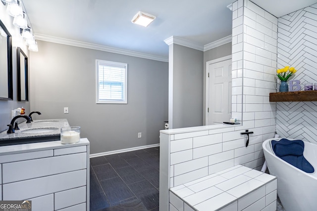 bathroom with baseboards, crown molding, vanity, a freestanding tub, and tile walls