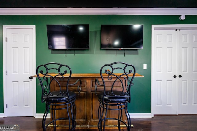 bar featuring a bar, baseboards, and wood finished floors