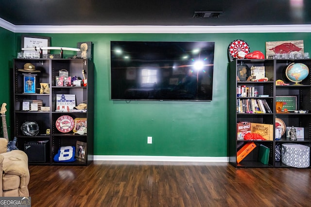 interior space with ornamental molding, visible vents, baseboards, and wood finished floors