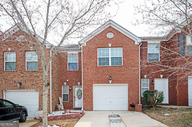 view of property featuring a garage, brick siding, and driveway