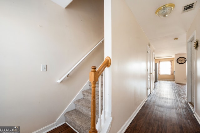 staircase with visible vents, baseboards, and wood finished floors