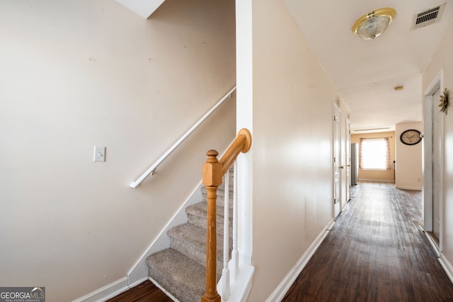 stairs featuring baseboards, visible vents, and wood finished floors
