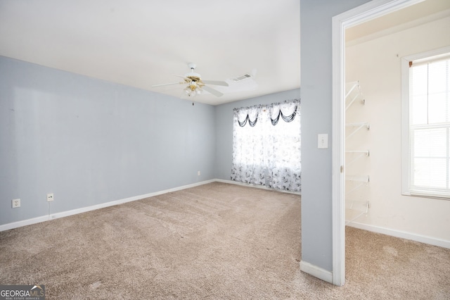 empty room featuring baseboards, a ceiling fan, visible vents, and carpet