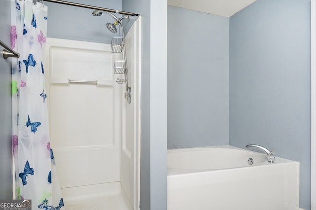 bathroom with a garden tub and curtained shower