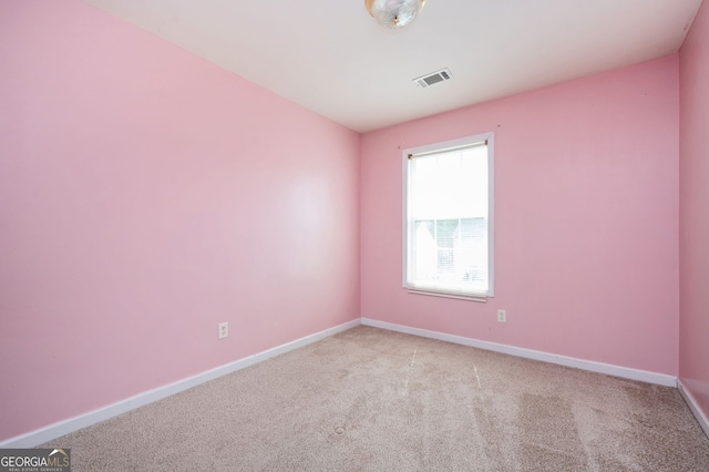 empty room with visible vents, light colored carpet, and baseboards