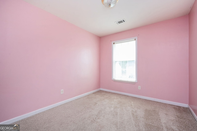 unfurnished room with light colored carpet, visible vents, and baseboards
