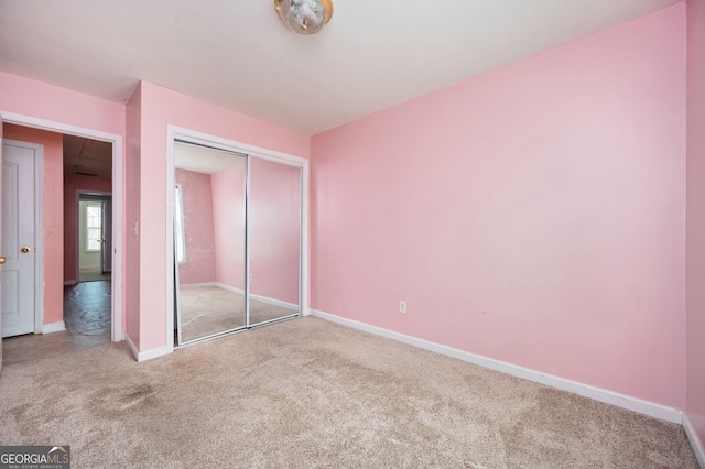 unfurnished bedroom with a closet, baseboards, and carpet