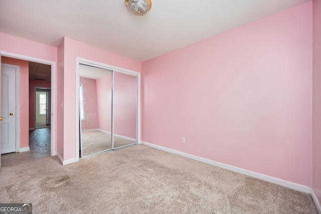 unfurnished bedroom with baseboards, carpet flooring, and a closet