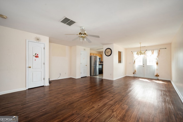 unfurnished living room featuring ceiling fan with notable chandelier, visible vents, baseboards, and dark wood-type flooring
