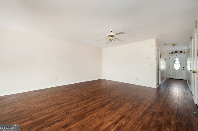 interior space with a ceiling fan, baseboards, and dark wood finished floors
