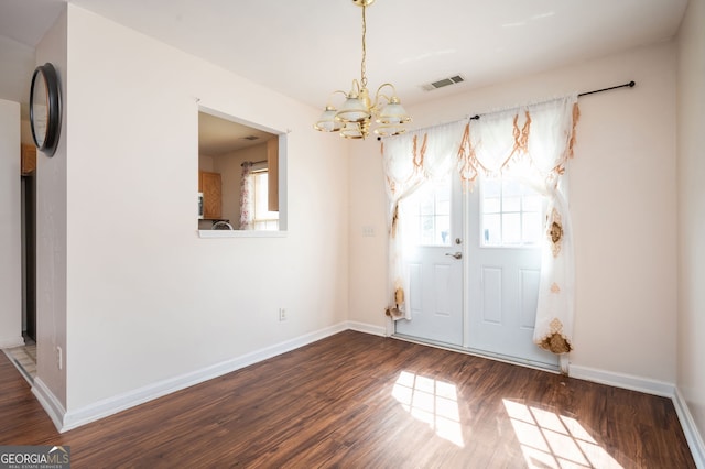 interior space with a chandelier, visible vents, dark wood-type flooring, and baseboards