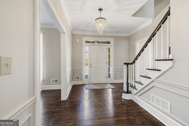 foyer featuring crown molding, visible vents, and wood finished floors