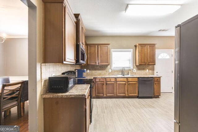 141 Back Cedar Ln, Warner Robins, GA 31093 - kitchen featuring brown cabinets, visible vents, a sink, and black appliances