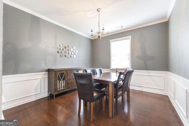 141 Back Cedar Ln, Warner Robins, GA 31093 - dining area with a chandelier, dark wood-style flooring, a wainscoted wall, and crown molding