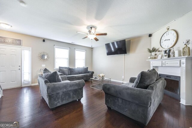 141 Back Cedar Ln, Warner Robins, GA 31093 - living room featuring dark wood finished floors, a textured ceiling, baseboards, and ceiling fan