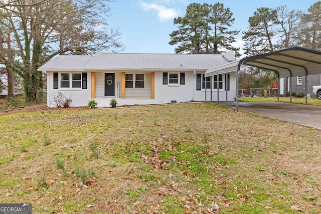 ranch-style home with a detached carport, concrete driveway, a front lawn, and metal roof