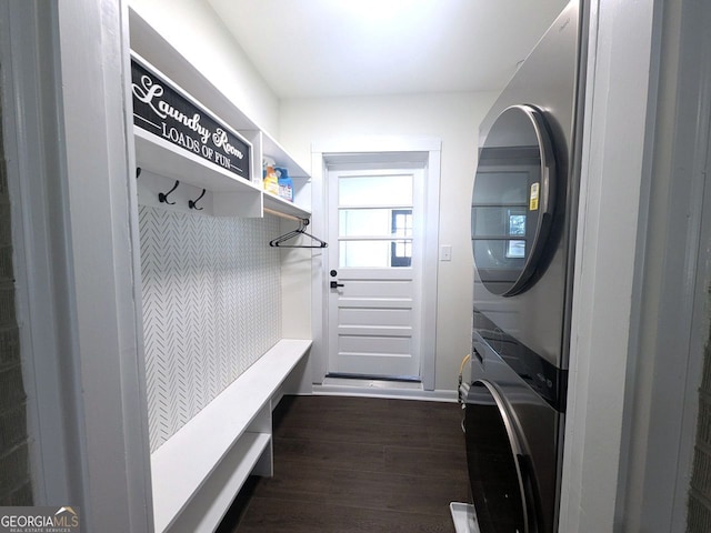mudroom featuring dark wood finished floors and stacked washer and dryer