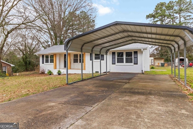 view of front of home featuring a front lawn, driveway, and a detached carport