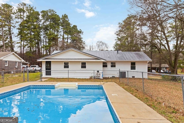 view of swimming pool with central AC, fence, and a fenced in pool