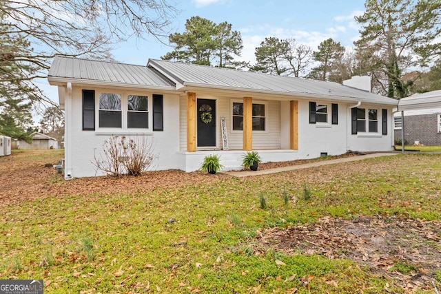 ranch-style home featuring brick siding, covered porch, a front yard, and metal roof