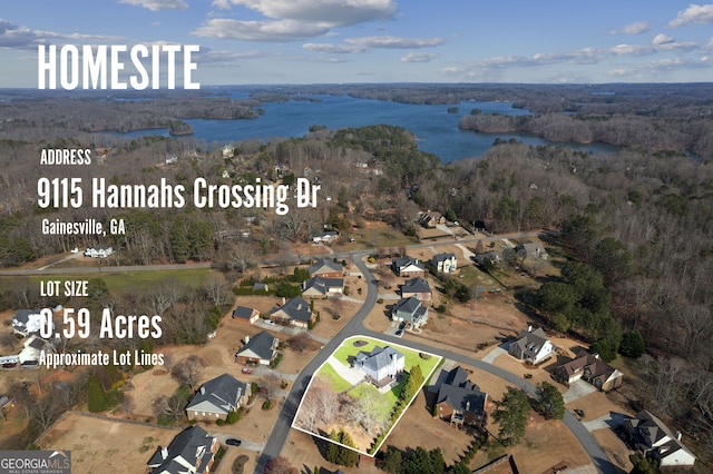 birds eye view of property featuring a water view and a wooded view