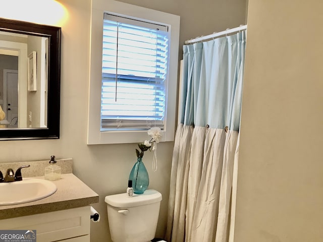 full bathroom with curtained shower, vanity, and toilet