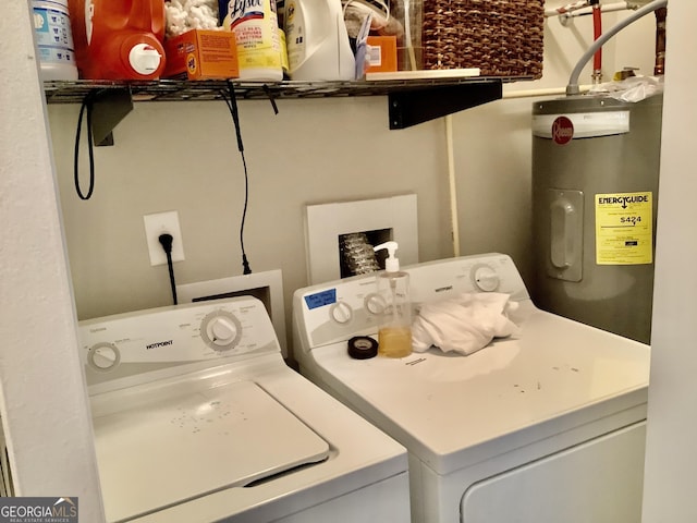 washroom featuring laundry area, water heater, and separate washer and dryer