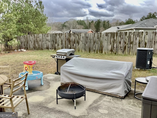 view of patio / terrace with fence, a fire pit, grilling area, and central AC unit