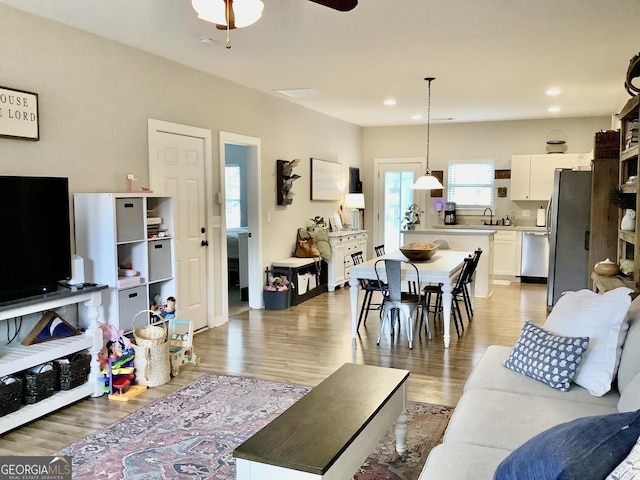 living room featuring a ceiling fan, recessed lighting, and light wood-style flooring