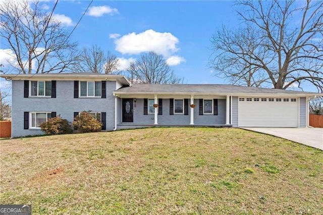 split level home featuring driveway, an attached garage, fence, and a front lawn