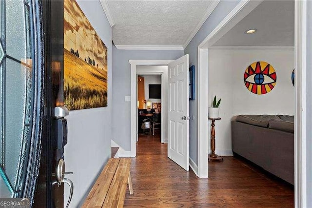 foyer entrance with crown molding, a textured ceiling, baseboards, and wood finished floors