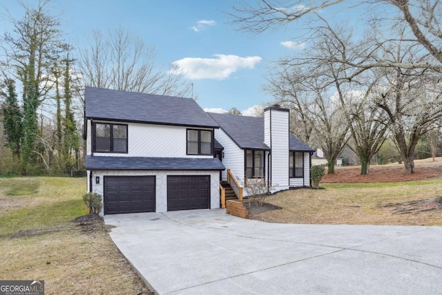 view of front facade with a garage, a shingled roof, concrete driveway, a chimney, and a front lawn