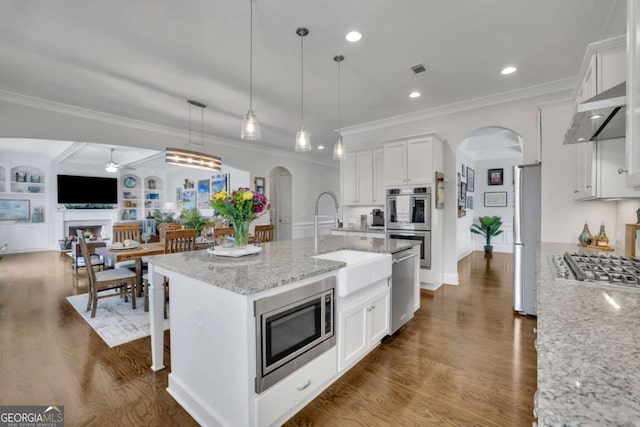 kitchen with a sink, white cabinets, appliances with stainless steel finishes, and dark wood-type flooring