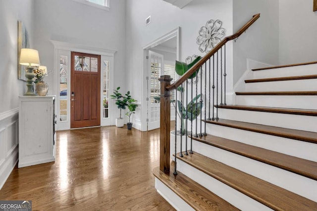 entryway with wood finished floors, stairs, and a wealth of natural light
