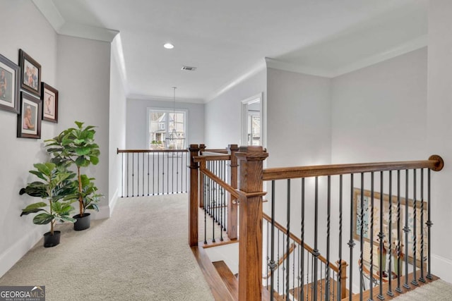 hall featuring ornamental molding, carpet floors, an upstairs landing, and visible vents