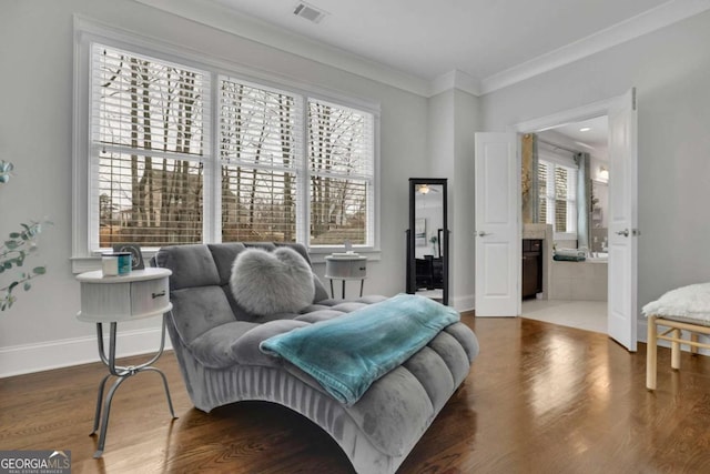 sitting room with visible vents, baseboards, crown molding, and wood finished floors