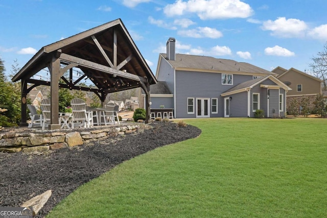 back of house featuring a chimney, a patio, a gazebo, and a lawn