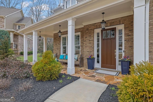 property entrance featuring brick siding and covered porch