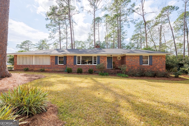 single story home with brick siding, a chimney, and a front lawn