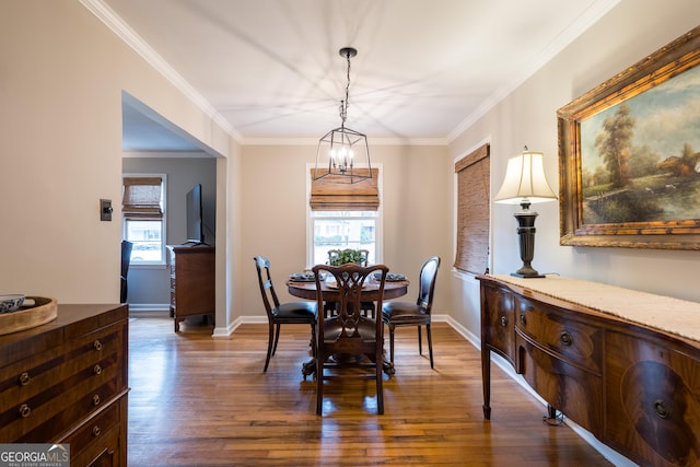 dining area featuring dark wood-type flooring, crown molding, and baseboards