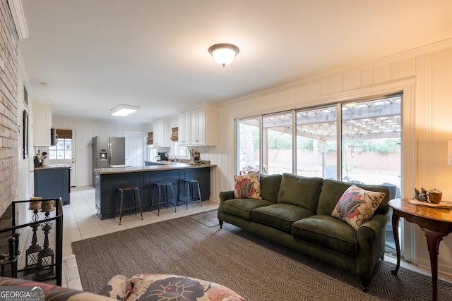 living area with light tile patterned floors and crown molding