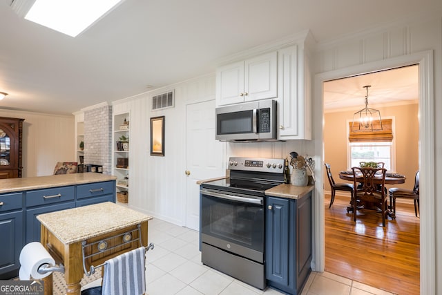 kitchen with ornamental molding, appliances with stainless steel finishes, blue cabinetry, and built in features